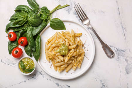 Plate with tasty pasta and pesto sauce on light backgroundの写真素材