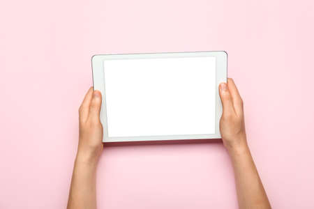 Hands with tablet computer on color background