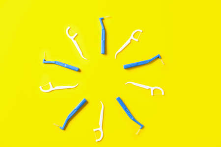 Frame made of toothbrushes for dental braces and floss on color backgroundの写真素材