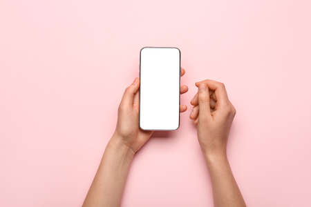 Hands with mobile phone on color backgroundの写真素材