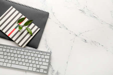 Computer keyboard and notebooks on light backgroundの写真素材