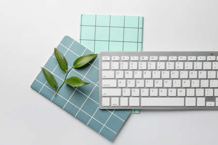 Computer keyboard and notebooks on white backgroundの写真素材