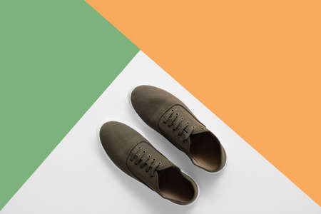 Casual male shoes on color background