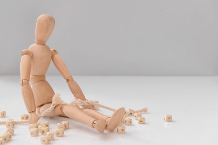 Wooden mannequin with rope on light background. Concept of stressの写真素材