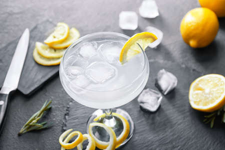 Glass of tasty martini with lemon on dark backgroundの写真素材