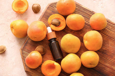 Bottles of apricot essential oil on color backgroundの写真素材