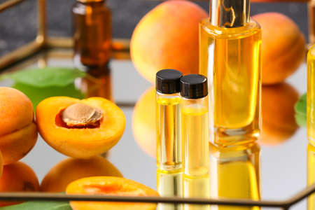 Bottles of apricot essential oil on trayの写真素材