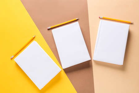 Blank books and pencils on color backgroundの写真素材