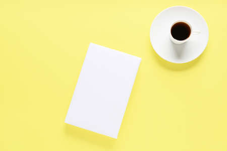 Blank book and cup of coffee on color backgroundの写真素材