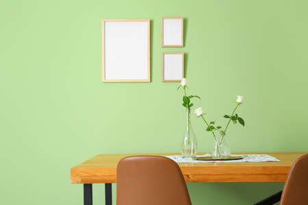 Table and chairs near color wall