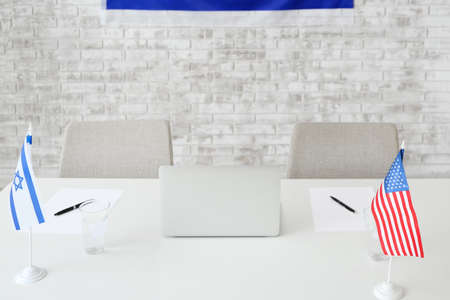 Flags of Israel and USA on table in embassy officeの写真素材