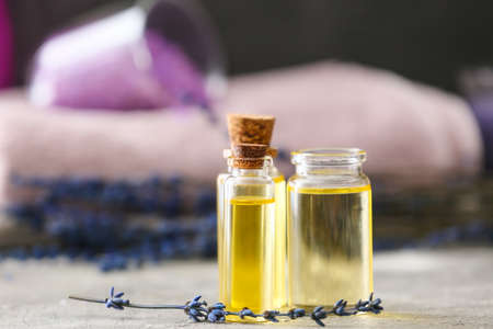 Bottles with lavender essential oil on tableの写真素材