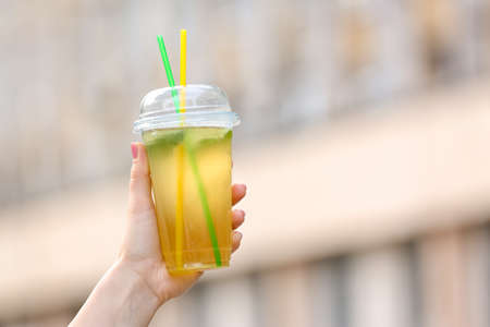 Woman drinking tasty cold ice tea outdoors