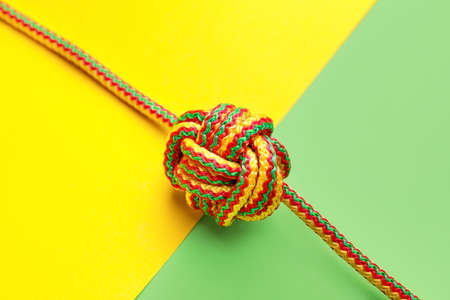 Rope with knot on color background