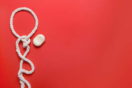 Soap and rope with knot on color backgroundの写真素材