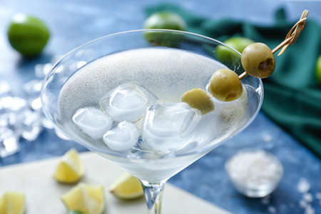 Glass of fresh martini on color background, closeup