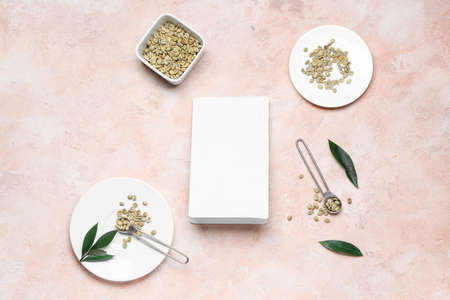 Blank coffee bag and green coffee beans on color background