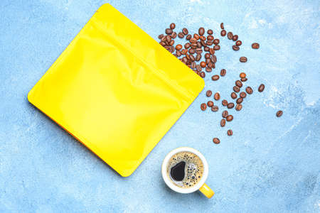Blank coffee bag and cup on color backgroundの写真素材