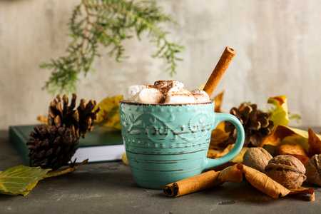 Cup of hot cacao drink with marshmallows and cinnamon on tableの写真素材