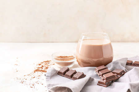 Glass of tasty chocolate milk on table
