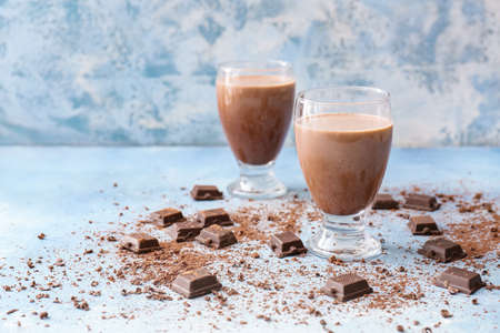 Glasses of tasty chocolate milk on color backgroundの写真素材