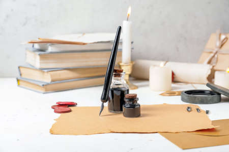 Composition with nib pen, paper sheets and inkwells on tableの写真素材