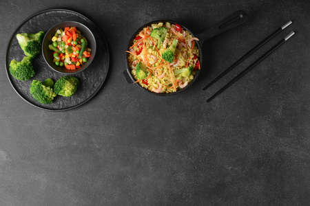 Frying pan with tasty rice and vegetables on dark backgroundの写真素材