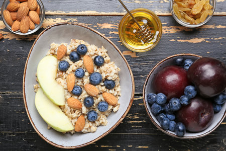Bowl with tasty sweet oatmeal on wooden tableの写真素材