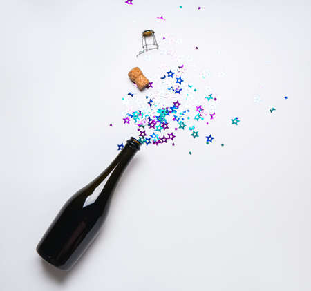 Bottle of champagne with glitters on light background. New Year celebrationの写真素材