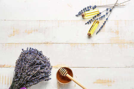 Lavender bouquet honey and bottles with essential oil on wooden backgroundの写真素材