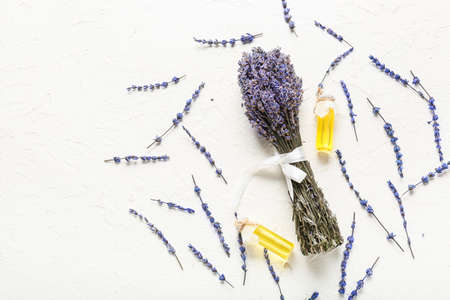 Lavender bouquet and bottles with essential oil on light backgroundの写真素材
