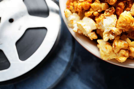 Popcorn with film reel on color background, closeupの写真素材