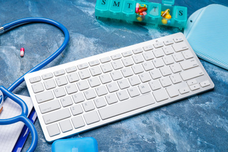 Computer keyboard and medical supplies on color tableの写真素材