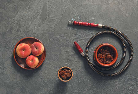 Parts of hookah and peaches on dark background