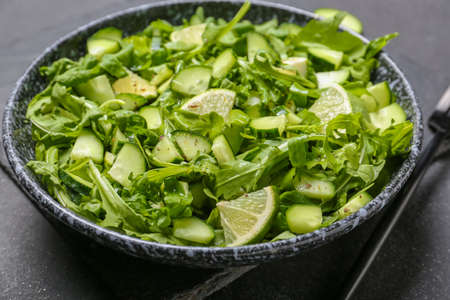 Plate with tasty cucumber salad on dark backgroundの写真素材