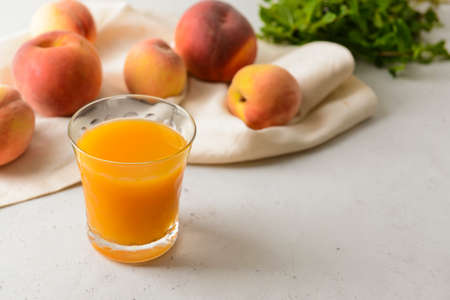 Glass of fresh peach juice on tableの写真素材