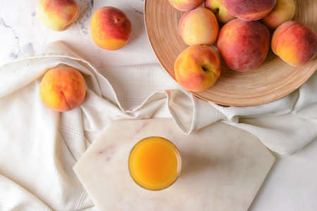 Composition with fresh peach juice on table