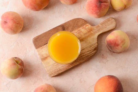 Glass of fresh peach juice on tableの写真素材