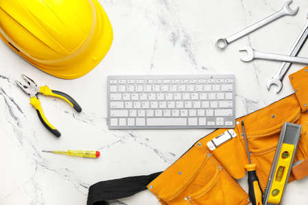 Construction tools and computer keyboard on light backgroundの写真素材