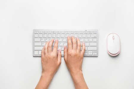 Female hands with computer keyboard on white background