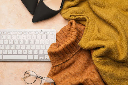 Computer keyboard, clothes and eyeglasses on color backgroundの写真素材