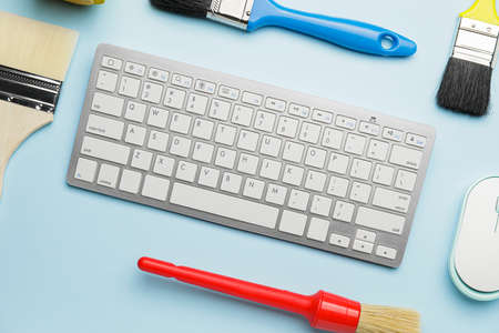 Computer keyboard, mouse and brushes on color tableの写真素材