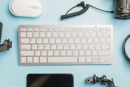 Computer keyboard and modern photographer's equipment on color tableの写真素材