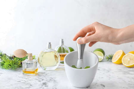 Woman preparing natural perfume on table