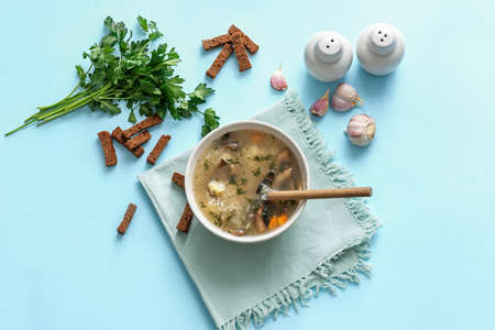Bowl of tasty rice soup on color background