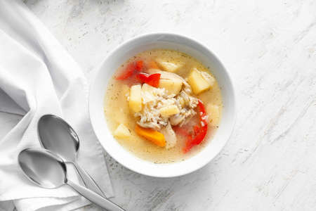 Bowl of tasty rice soup on table