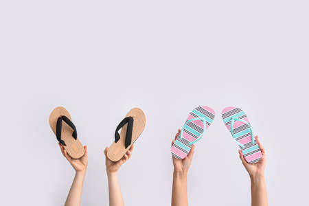 Hands with stylish shoes on white background