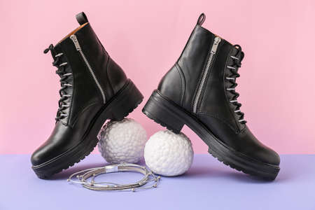 Female boots and accessories on color background