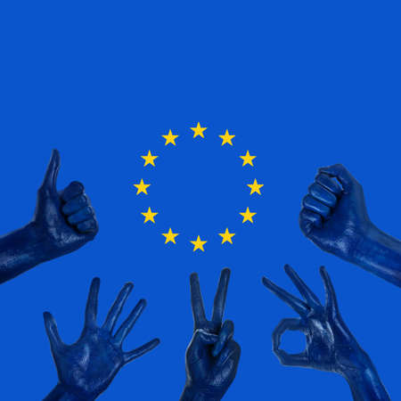 Many hands painted in colors of European Union flag on blue backgroundの写真素材