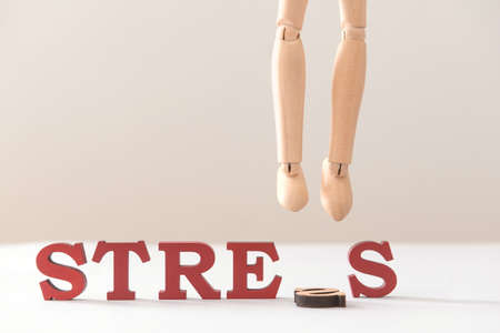 Hanged wooden human figure and word STRESS on light backgroundの写真素材